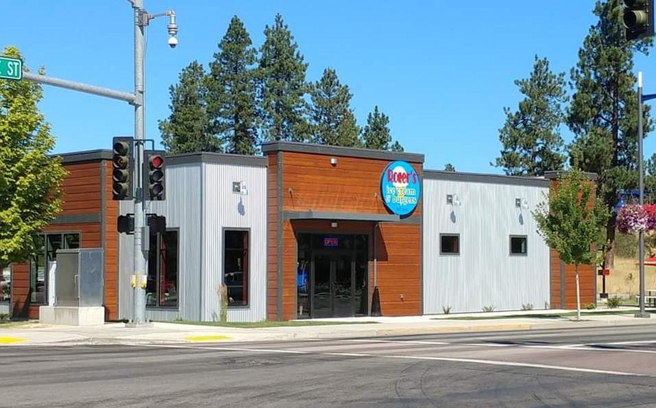 Main street view of Rogers Ice Cream and Burgers showing main entry storefront doors with metal and wood siding accents and round company signage in Post Falls ID location